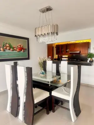 a dining room with a glass table and white chairs at Malecón view mar apartment in Colorado