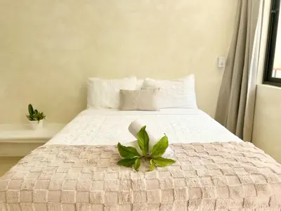 a white bed with a green plant on it at Luxury Family Villa With Pool Near Playa Bonita in Las Terrenas