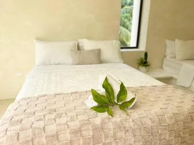 a white bed with a green plant on it at Luxury Family Villa With Pool Near Playa Bonita in Las Terrenas