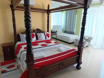 a bedroom with a large wooden bed with a canopy at Hotel Don Michele in Boca Chica
