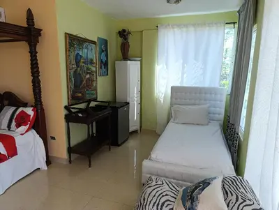a room with two beds and a desk and a window at Hotel Don Michele in Boca Chica