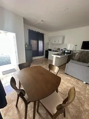 a kitchen with a wooden table and chairs in a room at Residencial JG in Punta Cana