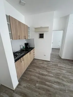 a kitchen with white walls and a wooden floor at La belle planque de Punta Cana- Playa 10 minutos a pie in Punta Cana