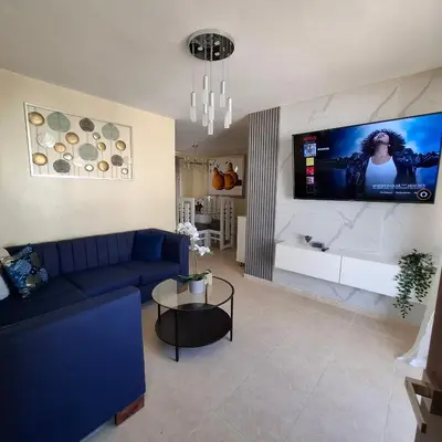 a living room with a blue couch and a tv at Las Palmas in Santiago de los Caballeros