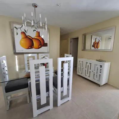 a dining room with white chairs and a dining table at Las Palmas in Santiago de los Caballeros