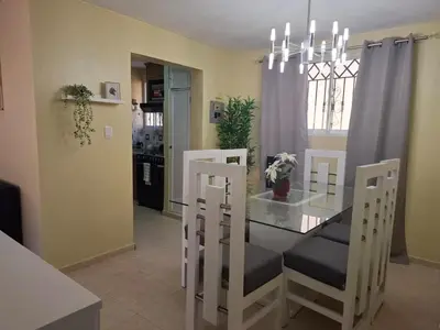 a dining room with a glass table and chairs at Las Palmas in Santiago de los Caballeros