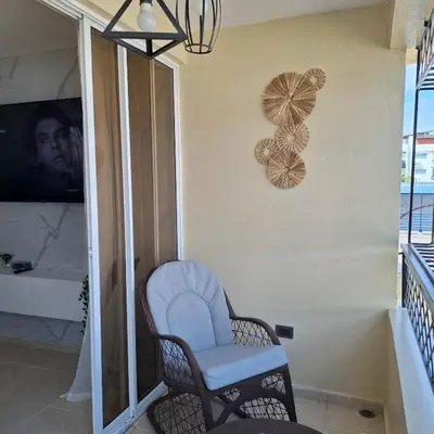 a room with a chair and a tv on a wall at Las Palmas in Santiago de los Caballeros