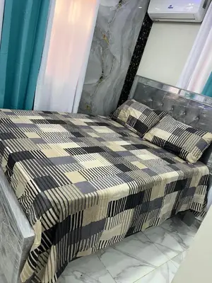 a bed with a checkered blanket on it at Moderna casa seca de aeropuerto SDQ y de mi rent cars in La Caleta