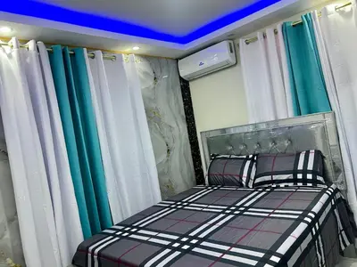 a bedroom with a bed with green and white curtains at Moderna casa seca de aeropuerto SDQ y de mi rent cars in La Caleta