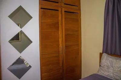 a bedroom with a wooden cabinet next to a bed at City Sea Exclusive Colonial Gem with Ocean View in Santo Domingo