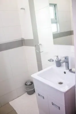 a white bathroom with a sink and a shower at City Sea Exclusive Colonial Gem with Ocean View in Santo Domingo