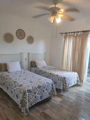 a bedroom with two beds and a ceiling fan at Residencial El Carey in Punta Cana