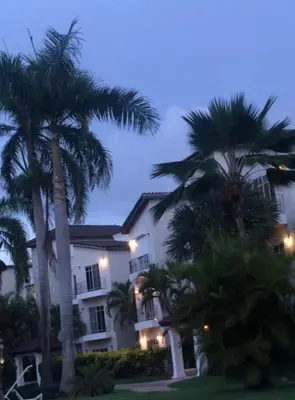 two palm trees in front of a building at Residencial El Carey in Punta Cana