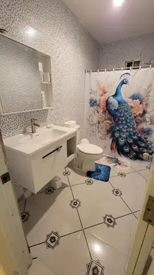 a bathroom with a peacock shower curtain and a sink at Descansa sin prisas a minutos del Aeropuerto in La Caleta