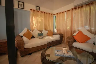 a living room with a couch and a glass table at The SeaDog Inn-Oceanfront Villa in Cabrera