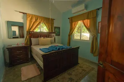 a bedroom with a bed with a dresser and a mirror at The SeaDog Inn-Oceanfront Villa in Cabrera