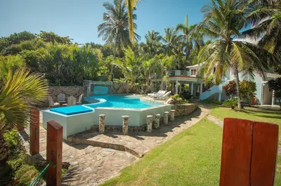 a villa with a swimming pool and a house at The SeaDog Inn-Oceanfront Villa in Cabrera