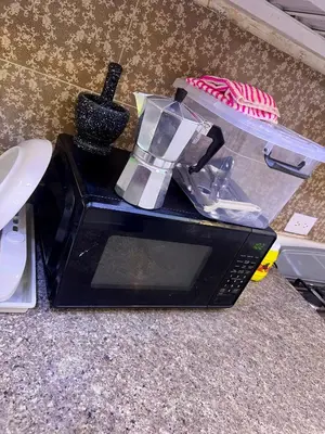 a black microwave sitting on top of a counter at Moderna casa cerca de el aeropuerto SDQ y mi rent cars in La Caleta