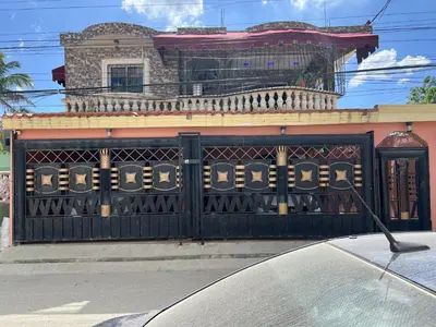 a black gate in front of a house at Moderna casa cerca de el aeropuerto SDQ y mi rent cars in La Caleta