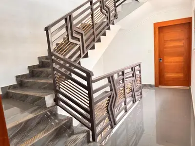 a metal staircase in a house with a wooden door at Santiago Amazing 4bedrooms Apt for group, spectacular WIFI, close to all fun in Santiago de los Caballeros