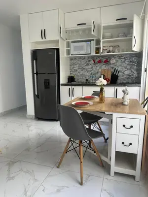 a kitchen with a table and a black refrigerator at Espectacular apartamento IV Albatros byJu Juan Dolió in Villas del Mar