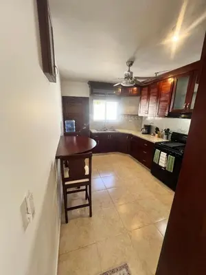a small kitchen with a table and a stove at Hermosa villa frente al mar in San Felipe de Puerto Plata