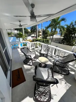 a patio with chairs and a table on a balcony at Hermosa villa frente al mar in San Felipe de Puerto Plata