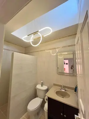 a bathroom with a toilet and a sink and a light at Hermosa villa frente al mar in San Felipe de Puerto Plata
