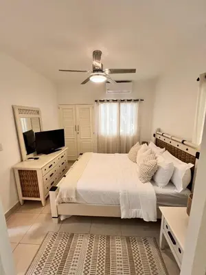 a bedroom with a bed and a ceiling fan at Hermosa villa frente al mar in San Felipe de Puerto Plata