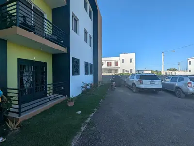 a parking lot with cars parked next to a building at Elegant apartment within a gated residential complex- 10 mins from Cabarete in Gaspar Hernández