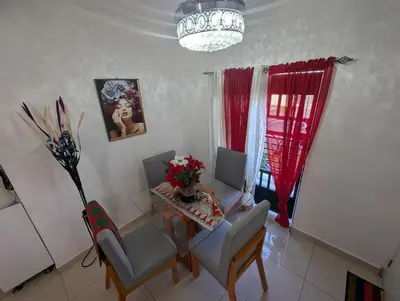a dining room with a table and two chairs and a table and chairsktop at Elegant apartment within a gated residential complex- 10 mins from Cabarete in Gaspar Hernández