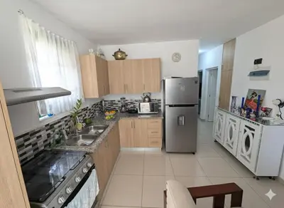 a kitchen with a stainless steel refrigerator and cabinets at Elegant apartment within a gated residential complex- 10 mins from Cabarete in Gaspar Hernández
