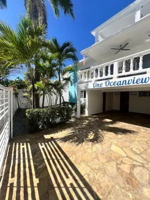 a white house with a one occupancy sign on it at Paraiso frente al mar in San Felipe de Puerto Plata