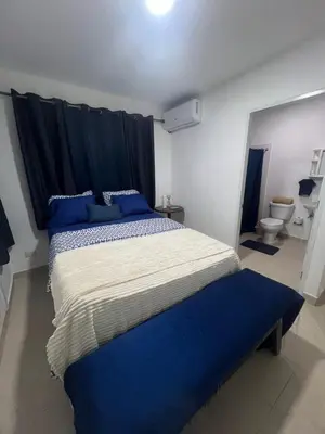 a bedroom with a large bed with blue pillows at Antares II in San Isidro