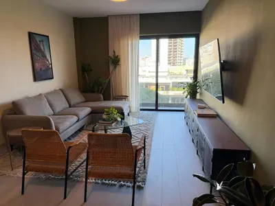 a living room with a couch and a table and chairs at Luxury 2-Bed Condo in Piantini Sauna, Gym, & Pool in Santo Domingo