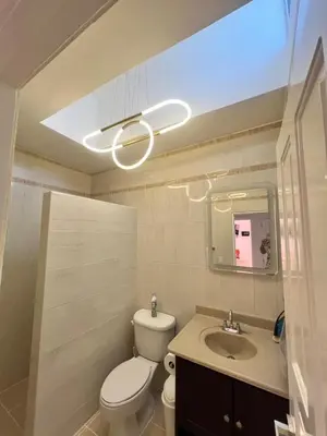 a bathroom with a toilet and a sink and a light at ocean view tropical in Maggiolo