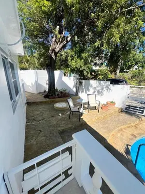 a patio with two chairs and a table and a tree at ocean view tropical in Maggiolo