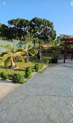 a person walking in a park with trees and plants at Villa Monte Alba in San Felipe de Puerto Plata