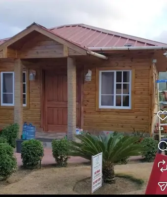 a log cabin with a red roof at Villa Monte Alba in San Felipe de Puerto Plata