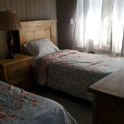 a bedroom with two beds and a table with a lamp at Villa Monte Alba in San Felipe de Puerto Plata