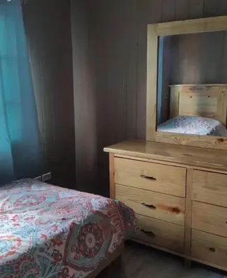 a bedroom with a bed and a dresser with a mirror at Villa Monte Alba in San Felipe de Puerto Plata
