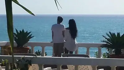 a man and woman standing on a balcony looking at the ocean at Ecolodge Vistamar in Los Patos