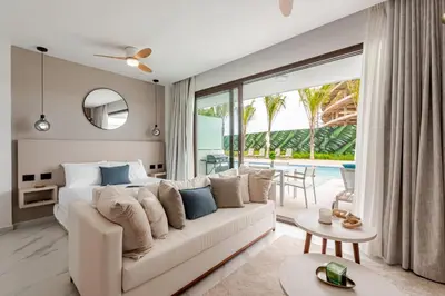 a bedroom with a white couch and a large window at Cana Rock Universe in Punta Cana