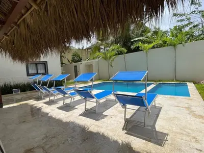 a row of blue chairs next to a swimming pool at Palmar Apartments Comfort Great Location in Punta Cana