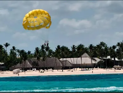 a yellow parachute is flying over a beach at Palmar Apartments Comfort Great Location in Punta Cana