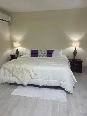 a bedroom with a large white bed with two lamps at Mayra House habitación independiente cerca del aeropuerto las Américas TAXI DISPONIBLE in Andrés