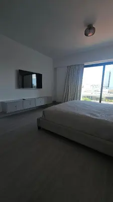 a bedroom with a bed and a flat screen tv at Luxury 2-Bed Condo in Piantini Sauna, Gym, and Pool in Santo Domingo