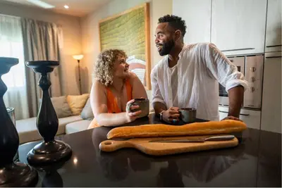 a man and woman sitting at a table in a kitchen at New* 3BR Loft | Pool | Patio | 2 mins to Beach in Las Terrenas