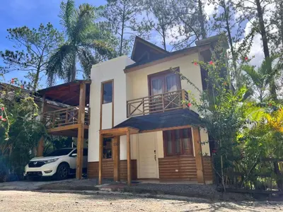 a house with a car parked in front of it at Villa Orquidea in Buena Vista