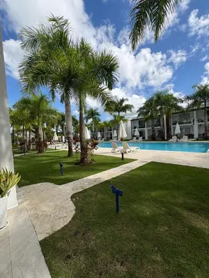 a resort yard with a swimming pool and palm trees at Boca paraiso in Boca Chica